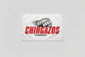 A white rectangular banner hanging on a concrete wall, printed with large red vertical text reading 'CHINGAZOS,' a black-and-white illustrated fist with claws, and small black website text. The banner has metal grommets at the corners.